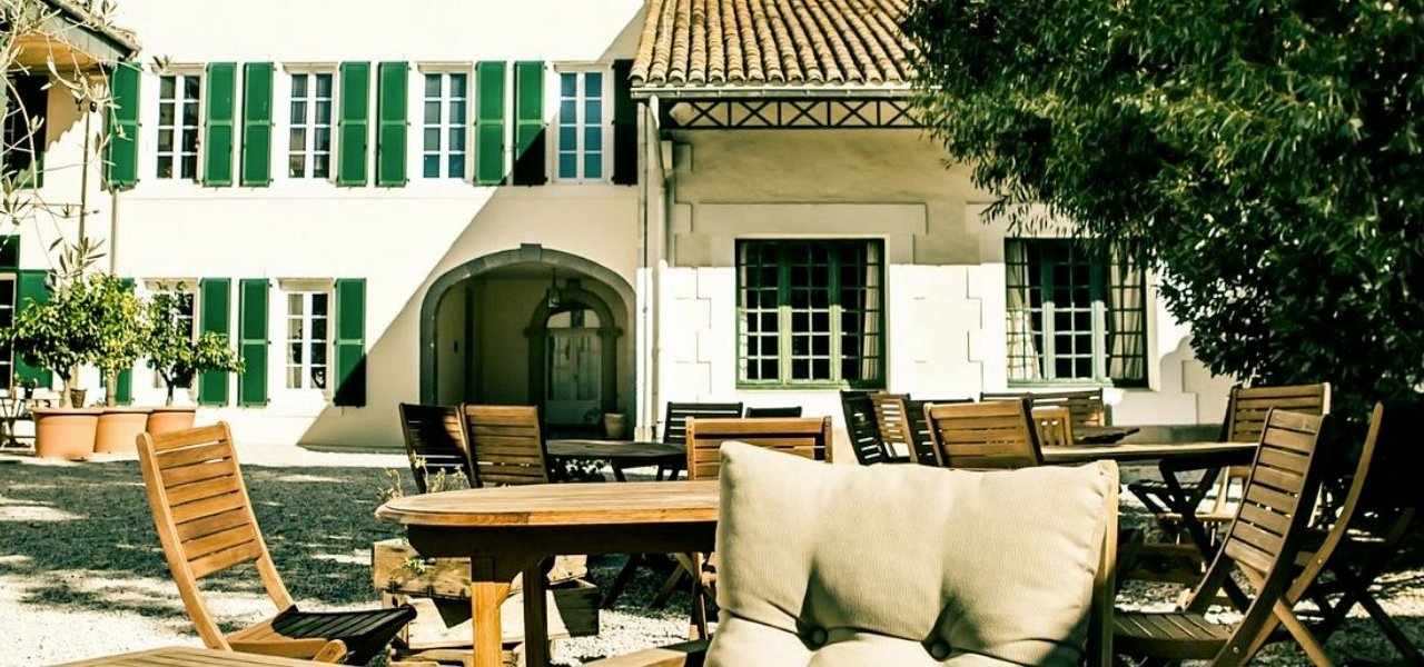 Tables en extérieur dans le magnifique jardin du château Noilly Prat, offrant un cadre idéal pour profiter du soleil et déguster un repas en plein air.
